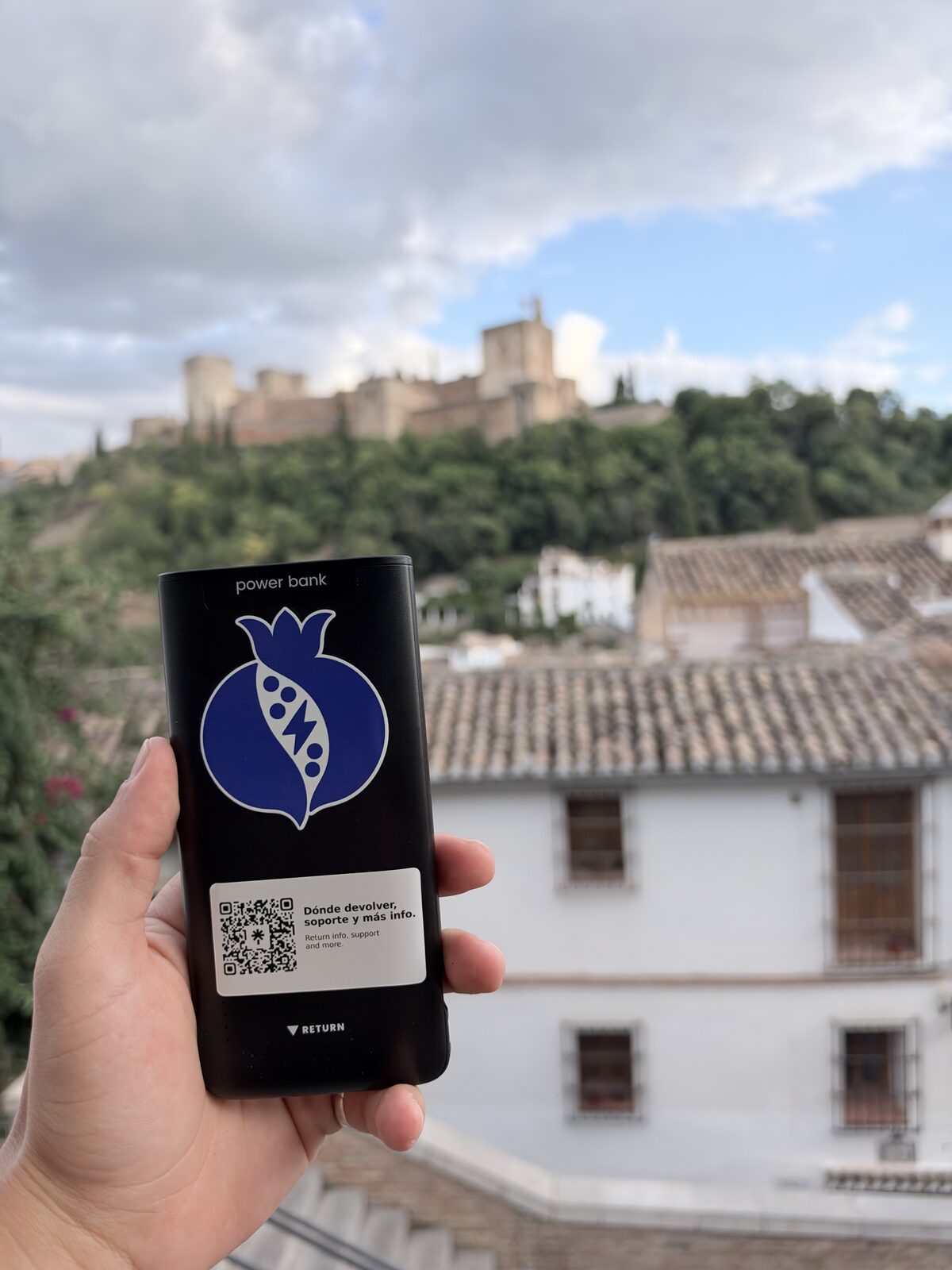 Mano sujetando una batería BateriGo con la Alhambra al fondo